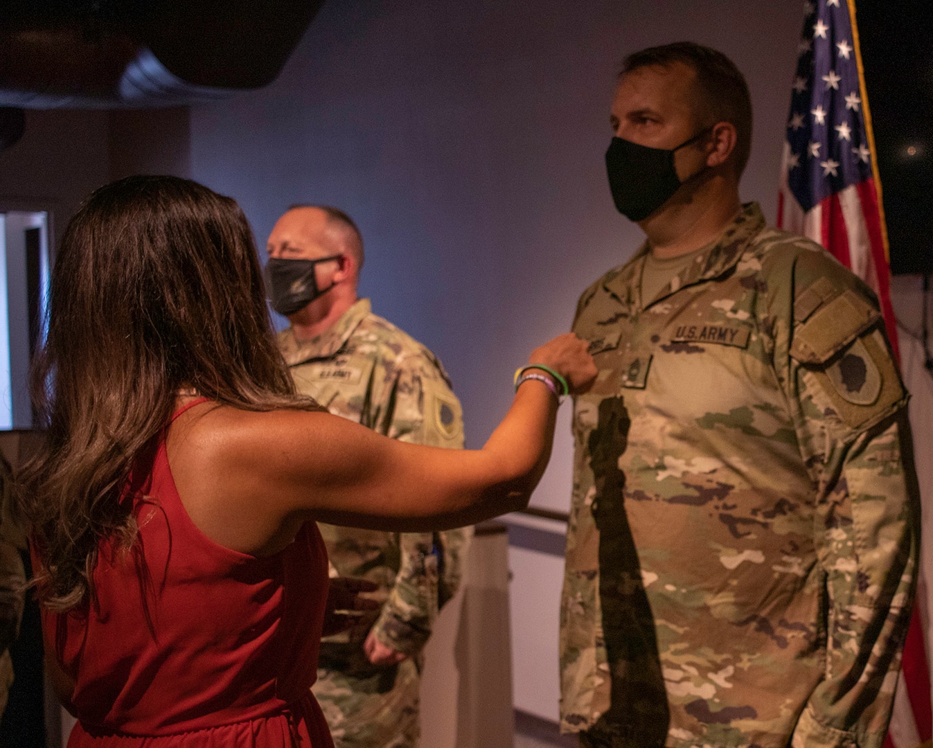 Tsoetsy Harris, wife of newly promoted Illinois Army National Guard Master Sgt. Matthew Harris, of Petersburg, Illinois, secures his new rank on his uniform during the promotion ceremony Sept. 16 at the Illinois State Military Museum, Springfield, Illinois.