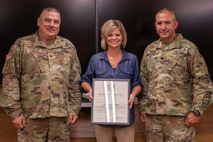 Tara Landon, wife of Lt. Col. Roger “Mike” Landon, of Petersburg, Illinois, accepts a Certificate of Appreciation from Col. Brian Creech, U.S. Property and Fiscal Officer for Illinois, during Landon’s retirement ceremony Sept. 30 at Joint Force Headquarters, Camp Lincoln, Springfield, Illinois.