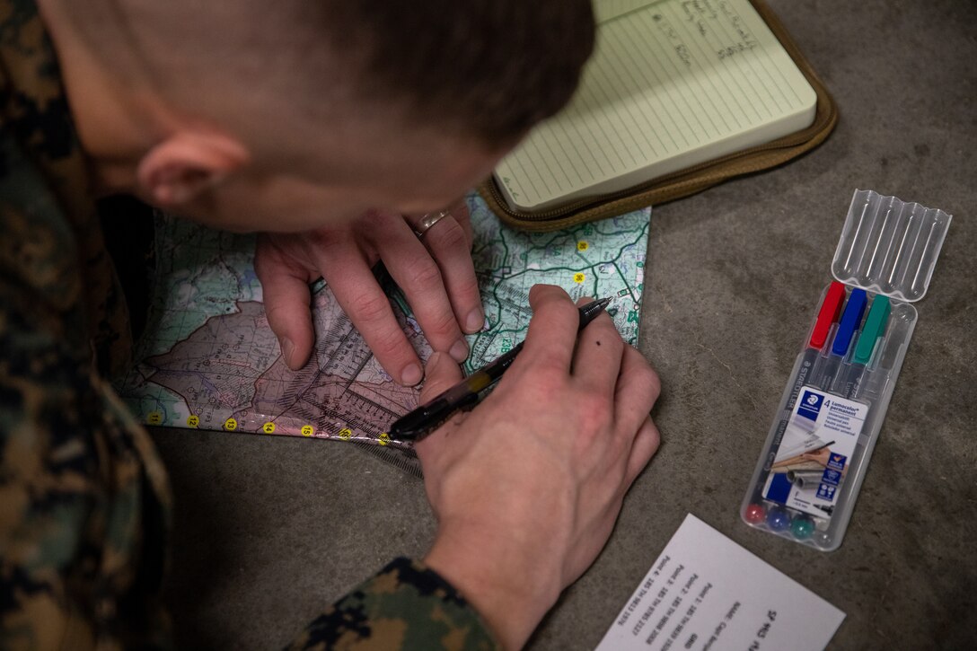 U.S. Marine Corps Capt. Benjamin Wright, an infantry officer with 1st Battalion, 6th Marine Regiment, 2d Marine Division (MARDIV), plot points on a map during Infantry Skills Test as part of the Division Leadership Assessment Program (DLAP) at Fort A.P. Hill, Va., Oct. 4, 2021. This program allows division leadership to mentor and assess captains recently assigned to 2d MARDIV on their mental, moral and physical readiness for future command opportunities. This contributes to the division’s mission to train and develop Marines that demonstrate an apex level of lethality, endurance, and comprehensive warfighting ability. (U.S. Marine Corps photo by Cpl. Juan Magadan)