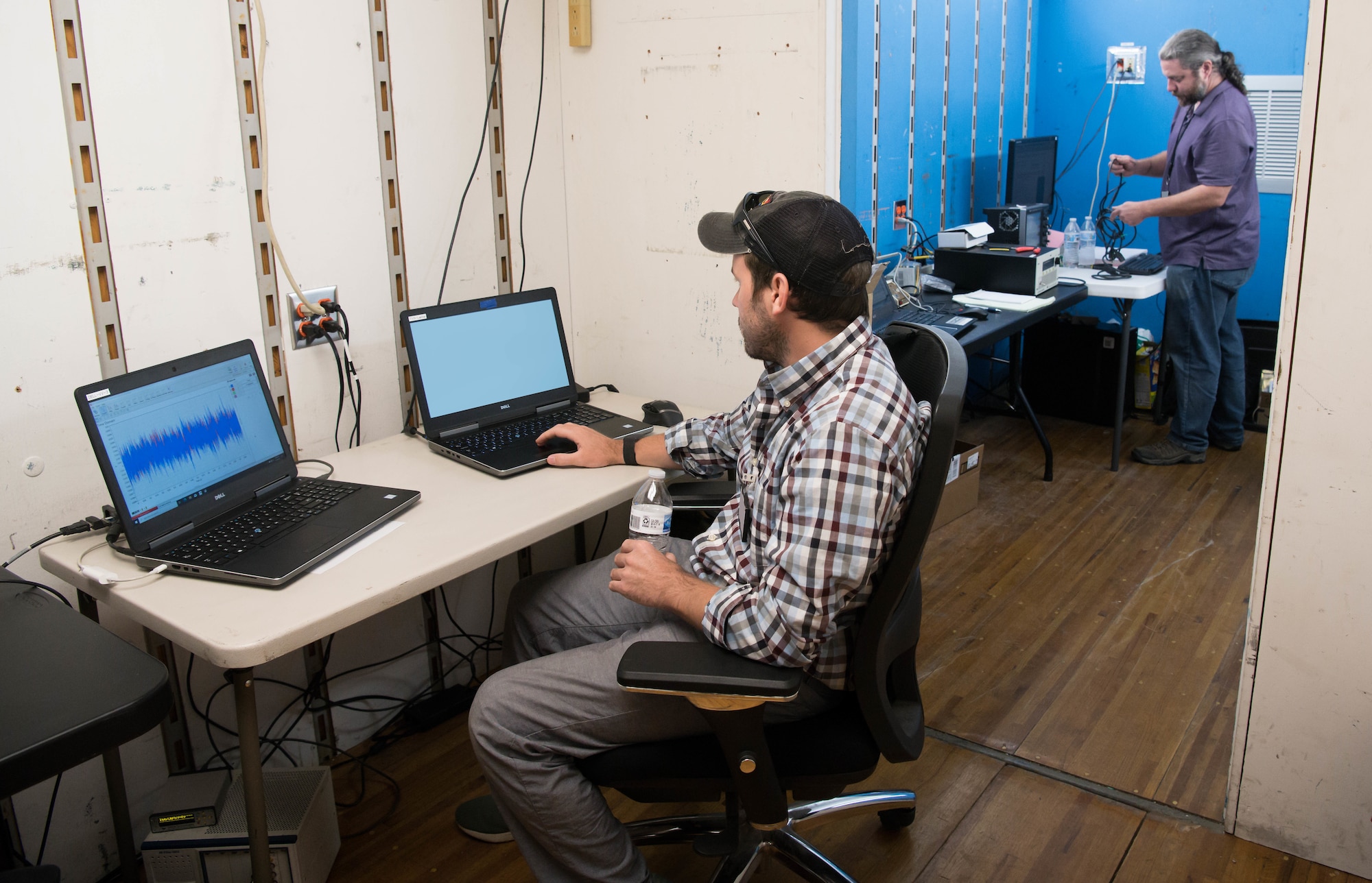 From left, Tim Shields, a senior engineer with Mechanical Solutions, Inc., and Richard Roth, a research engineer with Etegent Technologies, Ltd., set up equipment to conduct sensor validation testing using a General Electric F404 engine test in the Arnold Engineering Development Complex Sea Level Test Cell 1 at Arnold Air Force Base, Tenn., June 15, 2021. (U.S. Air Force photo by Jill Pickett) (This image has been altered by obscuring badges and a screen for security purposes.)
