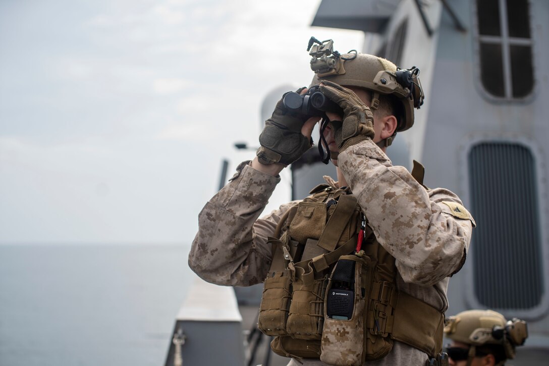 STRAIT OF HORMUZ (Oct. 4, 2021) Marine Corps Lance Cpl. Gerrit Olsen, a machine gunner assigned to Alpha Company, Battalion Landing Team 1/1, 11th Marine Expeditionary Unit (MEU), scans for nearby vessels while transiting the Strait of Hormuz aboard the amphibious transport dock USS Portland (LPD 27), Oct. 4. Portland and the 11th MEU are deployed to the U.S. 5th Fleet area of operations in support of naval operations to ensure maritime stability and security in the Central Region, connecting the Mediterranean and Pacific through the Western Indian Ocean and three strategic choke points. (U.S. Marine Corps photo by Lance Cpl. Patrick Katz/Released)