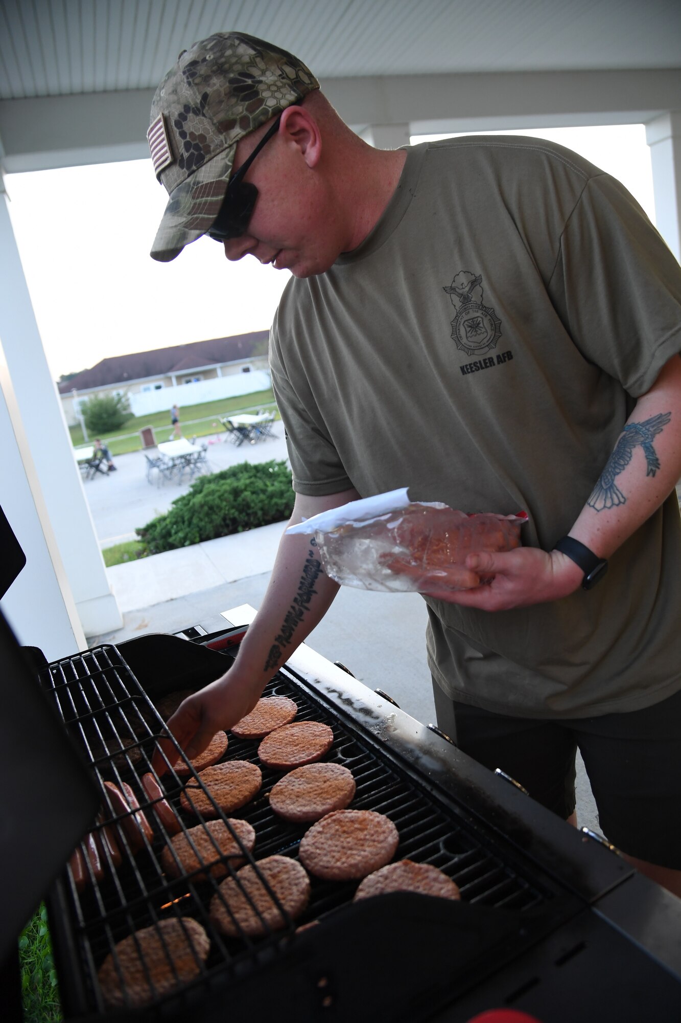 U.S. Air Force Tech. Sgt. Michael Daehnert, 81st Security Forces Squadron combat arms NCO in charge, grills burgers and hot dogs for Keesler families during the 81st SFS National Night Out at the Bay Ridge Community Center at Keesler Air Force Base, Mississippi, Oct. 5, 2021. The event, which was held to enhance the relationship between neighbors and law enforcement, included a military working dog demonstration, scavenger hunt and train rides. (U.S. Air Force photo by Kemberly Groue)