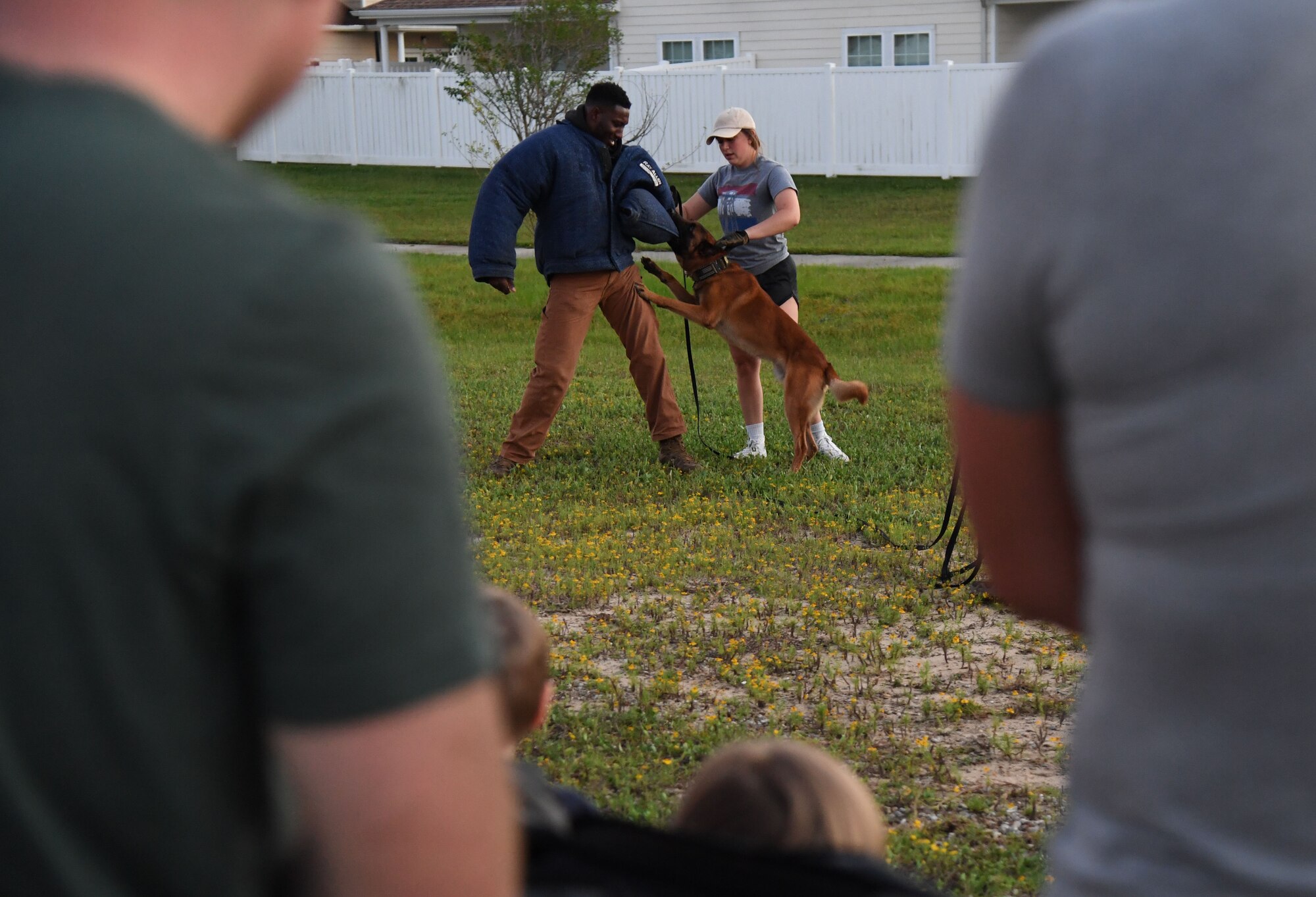 U.S. Air Force Senior Airman Ryan Wood and Staff Sgt. Victor Henderson, 81st Security Forces Squadron military working dog handlers, and Victor, 81st SFS military working dog, participate in a demonstration during the 81st SFS National Night Out at the Bay Ridge Community Center at Keesler Air Force Base, Mississippi, Oct. 5, 2021. The event, which was held to enhance the relationship between neighbors and law enforcement, included a military working dog demonstration, scavenger hunt and train rides. (U.S. Air Force photo by Kemberly Groue)