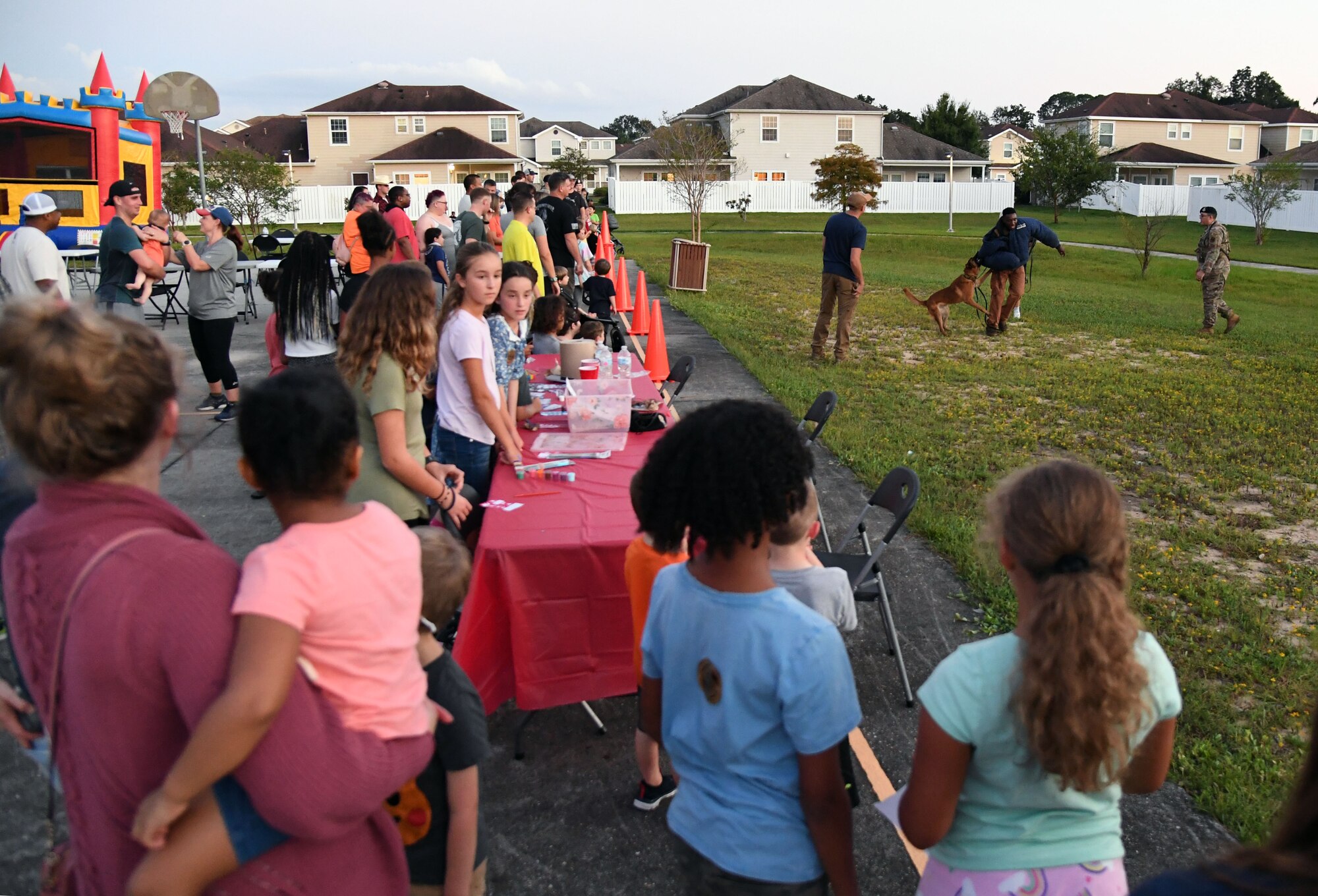 U.S. Air Force Senior Airman Ryan Wood and Staff Sgt. Victor Henderson, 81st Security Forces Squadron military working dog handlers, and Victor, 81st SFS military working dog, participate in a demonstration during the 81st SFS National Night Out at the Bay Ridge Community Center at Keesler Air Force Base, Mississippi, Oct. 5, 2021. The event, which was held to enhance the relationship between neighbors and law enforcement, included a military working dog demonstration, scavenger hunt and train rides. (U.S. Air Force photo by Kemberly Groue)