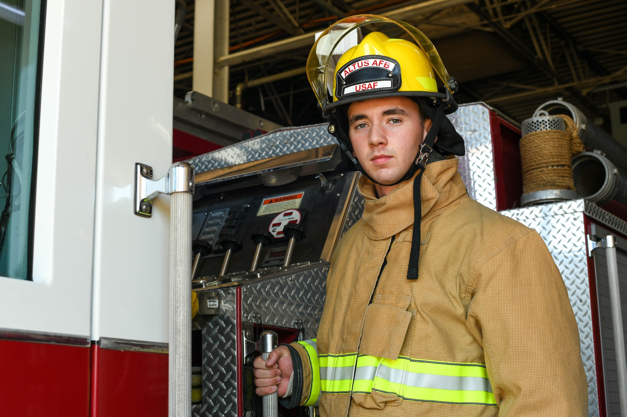 U.S. Air Force Airman 1st Class Joseph Coveney, 97th Civil Engineer Squadron (CES) fire prevention specialist, poses on Engine 11 at the fire department on Altus Air Force Base, Oklahoma, Oct. 4, 2021. The 97th CES Fire and Emergency Services Flight has more than 70 full time and part time staff. (U.S. Air Force photo by Airman 1st Class Trenton Jancze)