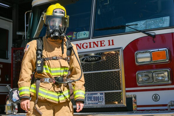 U.S. Air Force Airman 1st Class Joseph Coveney, 97th Civil Engineer Squadron (CES) fire prevention specialist, dons full gear in front of Engine 11 at the fire department on Altus Air Force Base, Oklahoma, Oct. 4, 2021. Coveney hails from a family of military and firefighters, who inspired him to enlist and be a firefighter himself. (U.S. Air Force photo by Airman 1st Class Trenton Jancze)