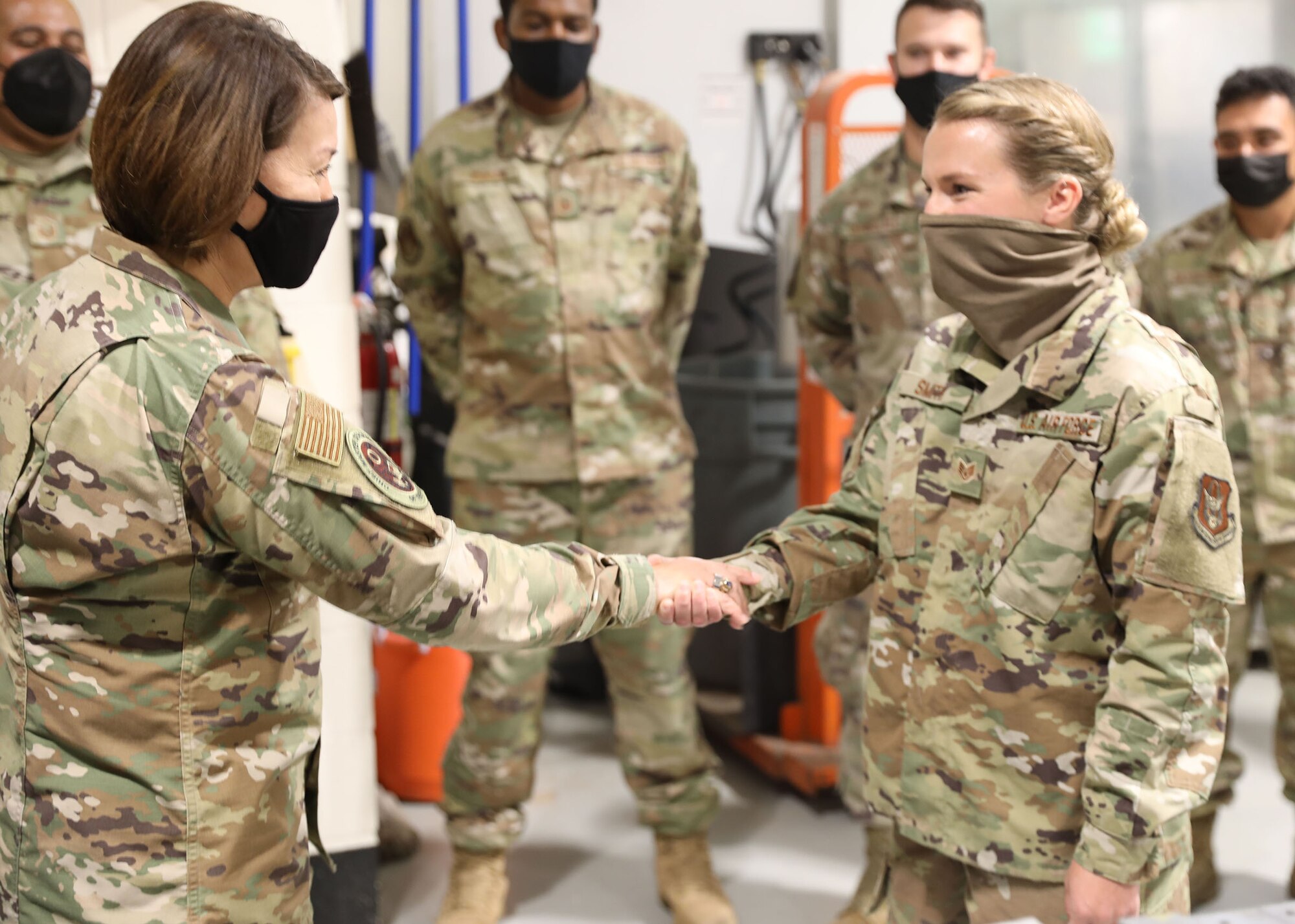 Chief Master Sgt. of the Air Force JoAnne S. Bass coins Staff Sgt. Leslie Smith, 445th Maintenance Squadron non-destructive inspection journeyman, for being an exceptional performer in her unit at Wright-Patterson Air Force Base, Ohio, Oct. 2, 2021. Smith is an outstanding performer because she led 57 non-destructive inspections to ensure six aircraft tasked to support Operation Allies Refuge were safe for flight.