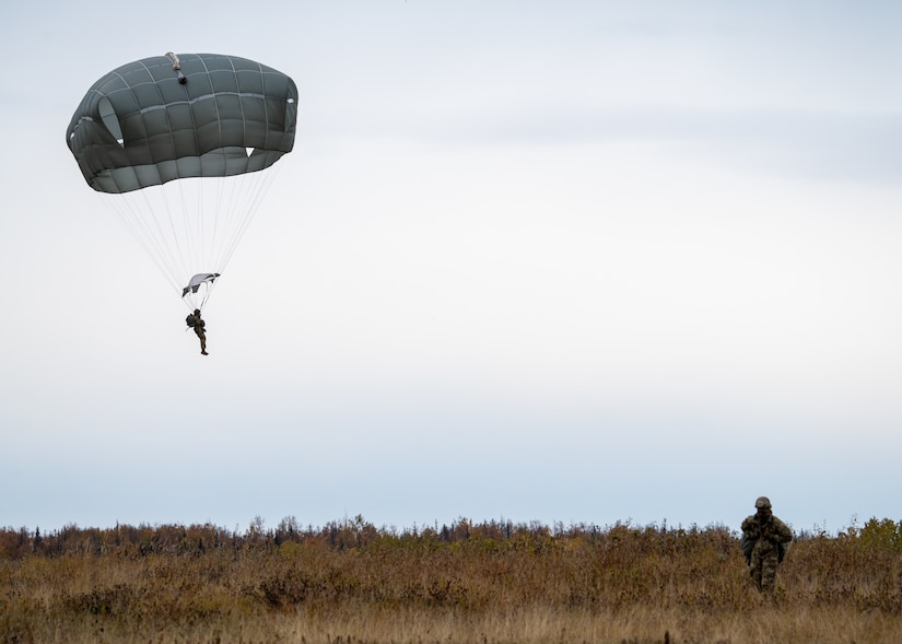 U.S. Army paratroopers assigned to the 4th Infantry Brigade Combat Team (Airborne), 25th Infantry Division, U.S. Army Alaska, land after jumping from a CH-47 Chinook.