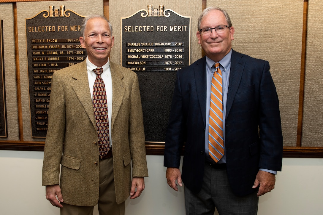 Mike Wilson (Right) and Mark Kuhlo, 2021 Distinguished Civilian Employee Recognition Award recipients, pose by their nameplates on a bronze plaque highlighting their recognition Oct. 6, 2021 at the Nashville District Headquarters in Nashville, Tennessee. Wilson retired in 2017 following 42 years of federal service, culminating his career as deputy district engineer for Project Management. Kuhlo retired in 2016 following 35 years of federal service, culminating his career as chief of the Electrical and Mechanical Branch. (USACE Photo by Lee Roberts)