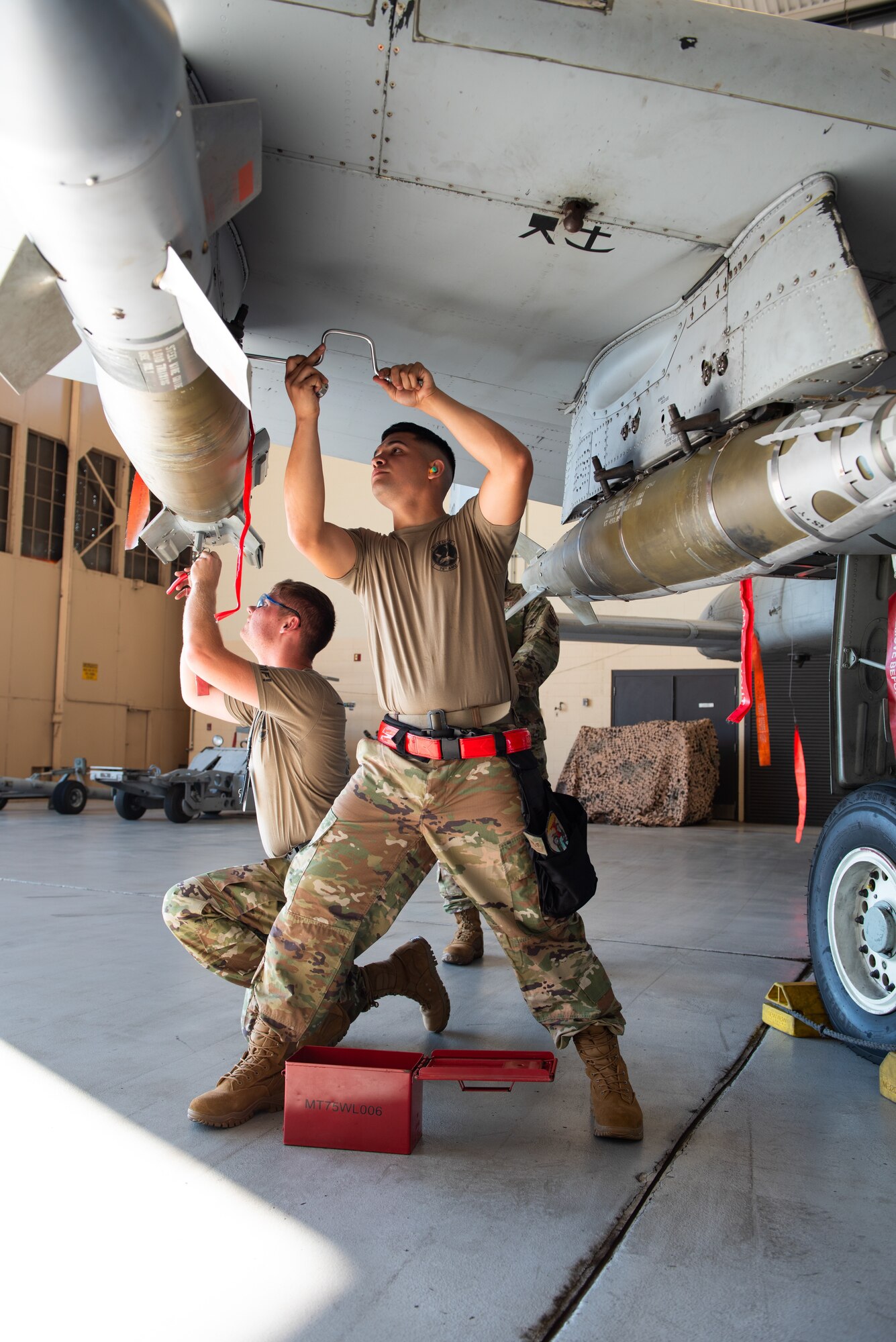 two men loading missiles on a plane
