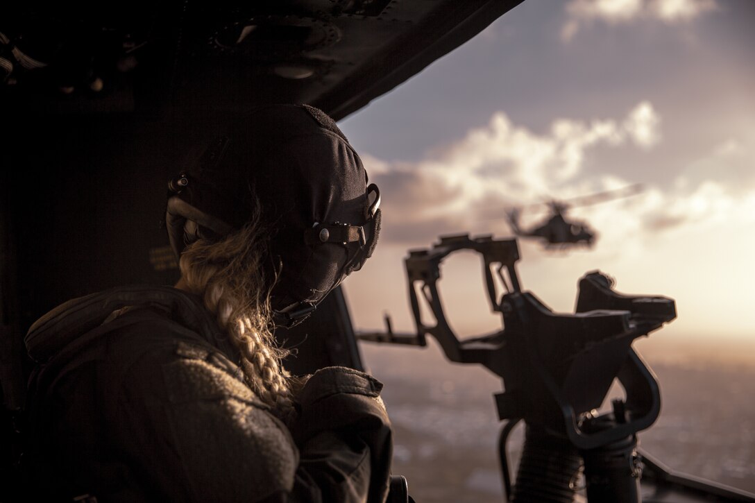 U.S. Marine Corps Cpl. Katelynne Eber, a UH-1Y Venom helicopter crew chief with Marine Light Attack Helicopter Squadron 169, 1st Marine Aircraft Wing, scans the horizon while flying over Okinawa, Japan, Sept 29, 2021. HMLA-169 conducted a Strike Coordination and Reconnaissance drill in order to increase proficiency and lethality throughout the squadron.