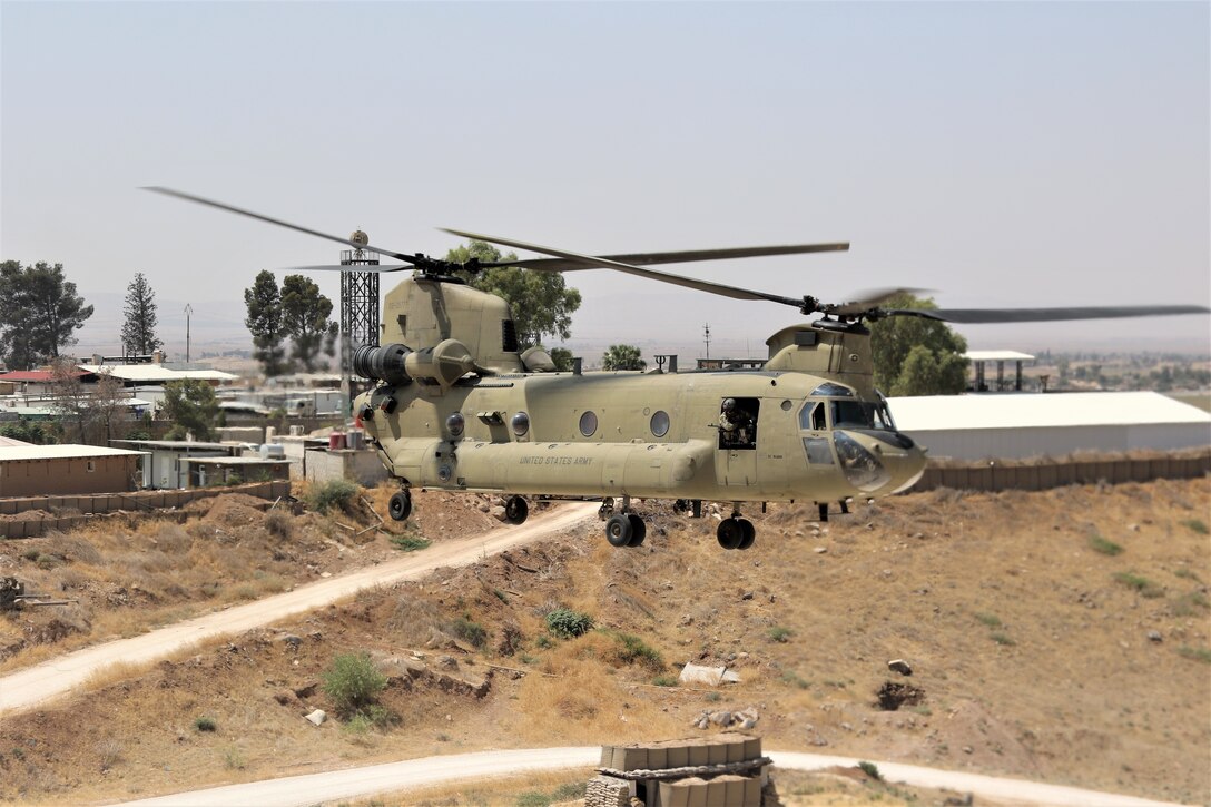 A Task Force Phoenix CH-47 Chinook helicopter from B Company, 1st Battalion, 171st Aviation Regiment (General Support Aviation Battalion), lifts off at a forward operating base in Syria.