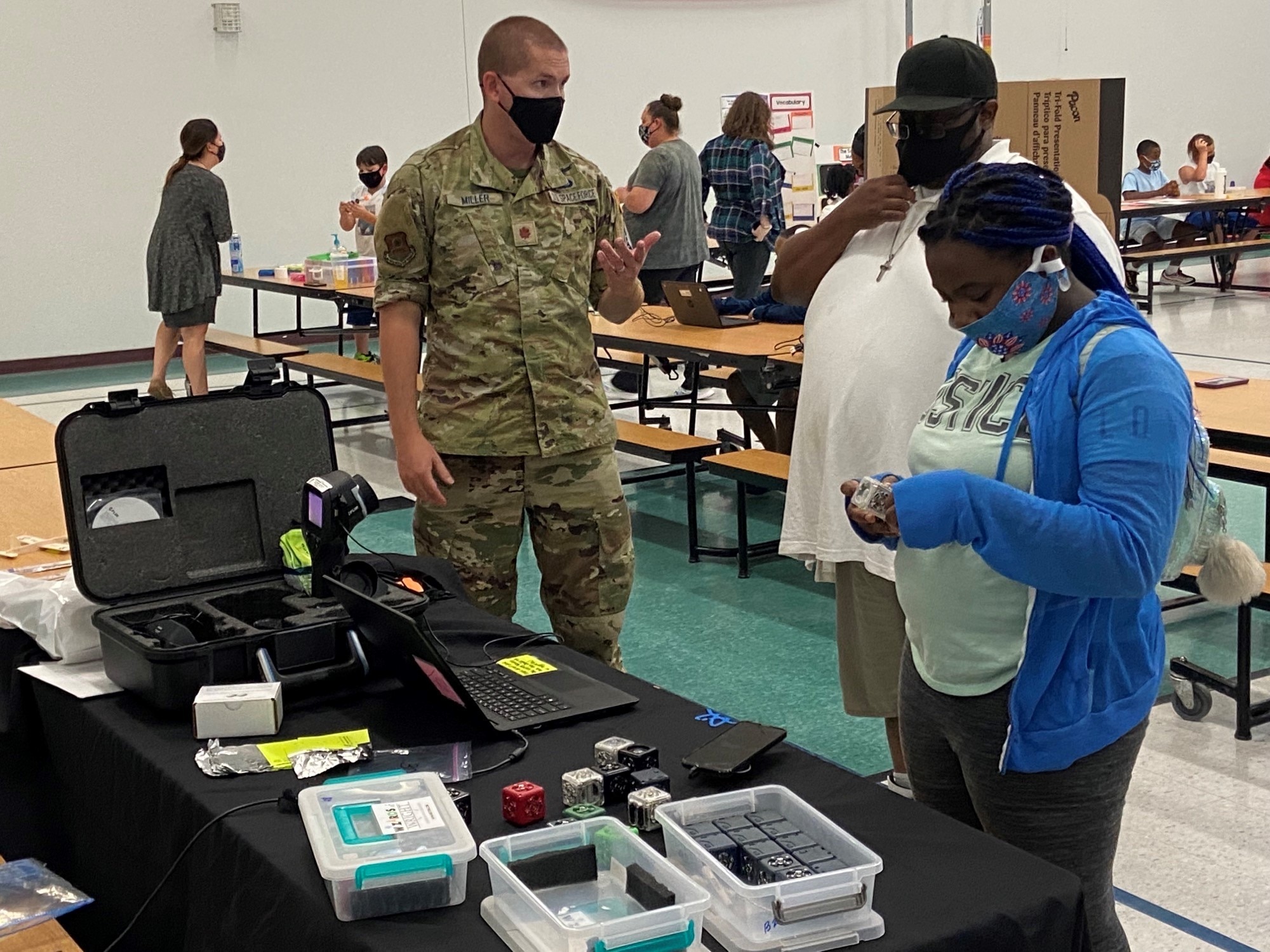 Maj. Daniel Miller, an Air Force Institute of Technology student, explains how the new Air Force Research Laboratory cubelet’s work to a student and her parent during North Dayton School of Discovery’s first STEM night Sept. 16. (Contributed photo)