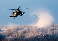 An Alaska Army National Guard UH-60 Black Hawk assigned to the National Guard Readiness Center in Bethel, Alaska, carries volunteers during Operation Santa Claus in Napakiak, Alaska, Dec. 3, 2019. Operation Santa Claus is an annual event hosted by the Alaska National Guard and the Salvation Army. The Alaska National Guard started the event in 1956 and was joined by the Salvation Army more than 40 years ago. This partnership serves as a way for the military to care for isolated villages. Napaiak is a village in western Alaska with a population of around 350 people. Volunteers flew into the village to deliver gifts, school supplies, backpacks, ice cream and an opportunity to take a photo with Santa for the entire community. (U.S. Air Force photo by Airman 1st Class Emily Farnsworth)