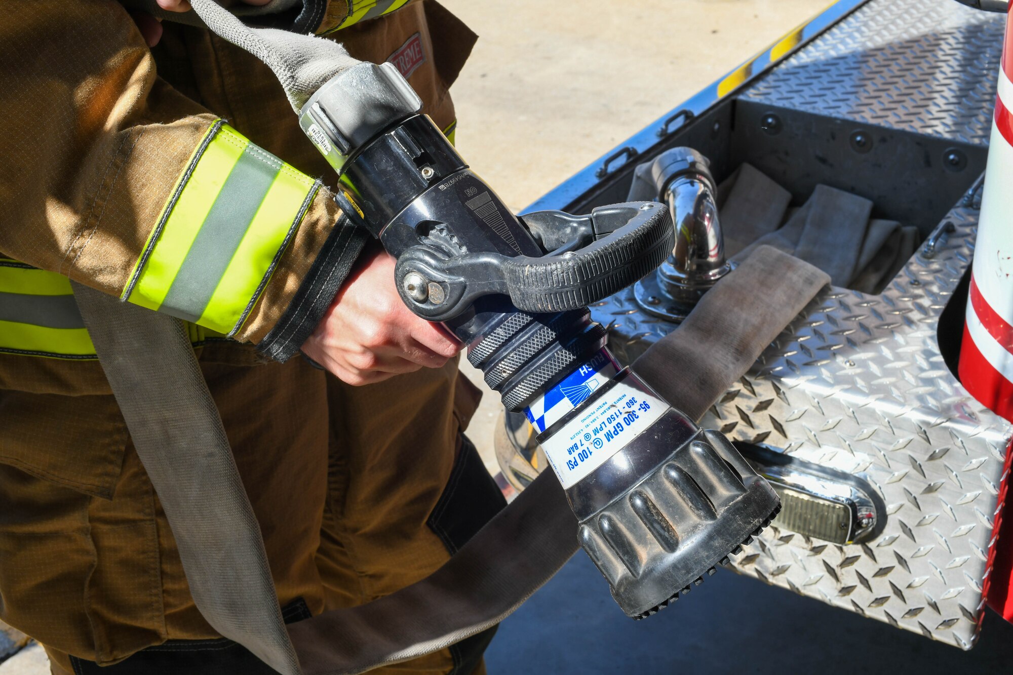 U.S. Air Force Airman 1st Class Joseph Coveney, 97th Civil Engineer Squadron (CES) fire prevention specialist, shows off one of the hoses attached to Engine 11 at the fire department on Altus Air Force Base, Oklahoma, Oct. 4, 2021. The fire hose is one of the basic, essential pieces of firefighting equipment. (U.S. Air Force photo by Airman 1st Class Trenton Jancze)