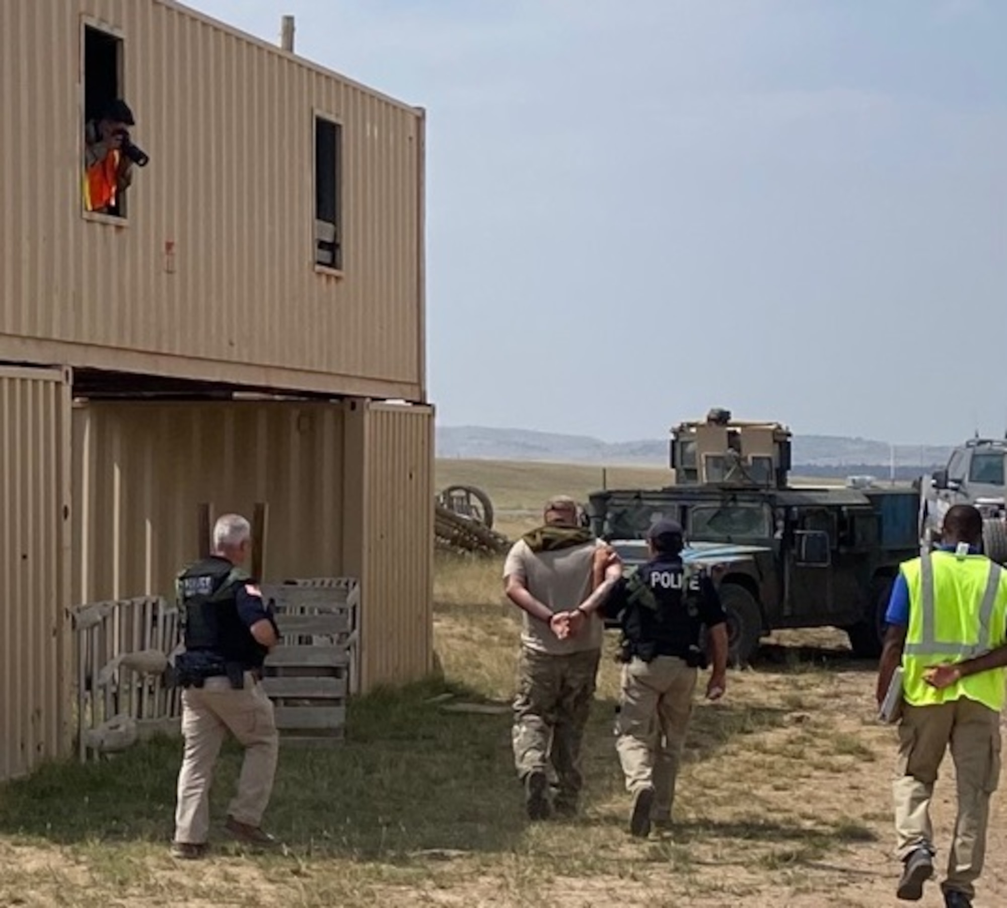 Office of Special Investigations Nuclear Convoy Support Agents from Field Investigations Region 8, arrest a hostile "terrorist" and lead him to the FBI, while a photographer documents the scenario during the Air Force Global Strike Command’s Road Warrior Exercise at Camp Guernsey, Wyo., Aug. 9-20, 2021. (Photo by Col. Seth Miller, 8 FIR/CC)