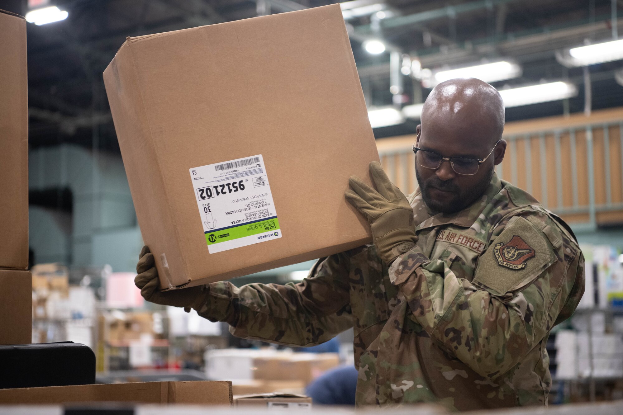 Airman hoists up a medical supply box
