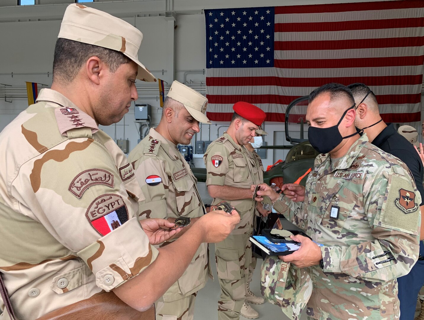 Major handing out IAAFA patches in hangar