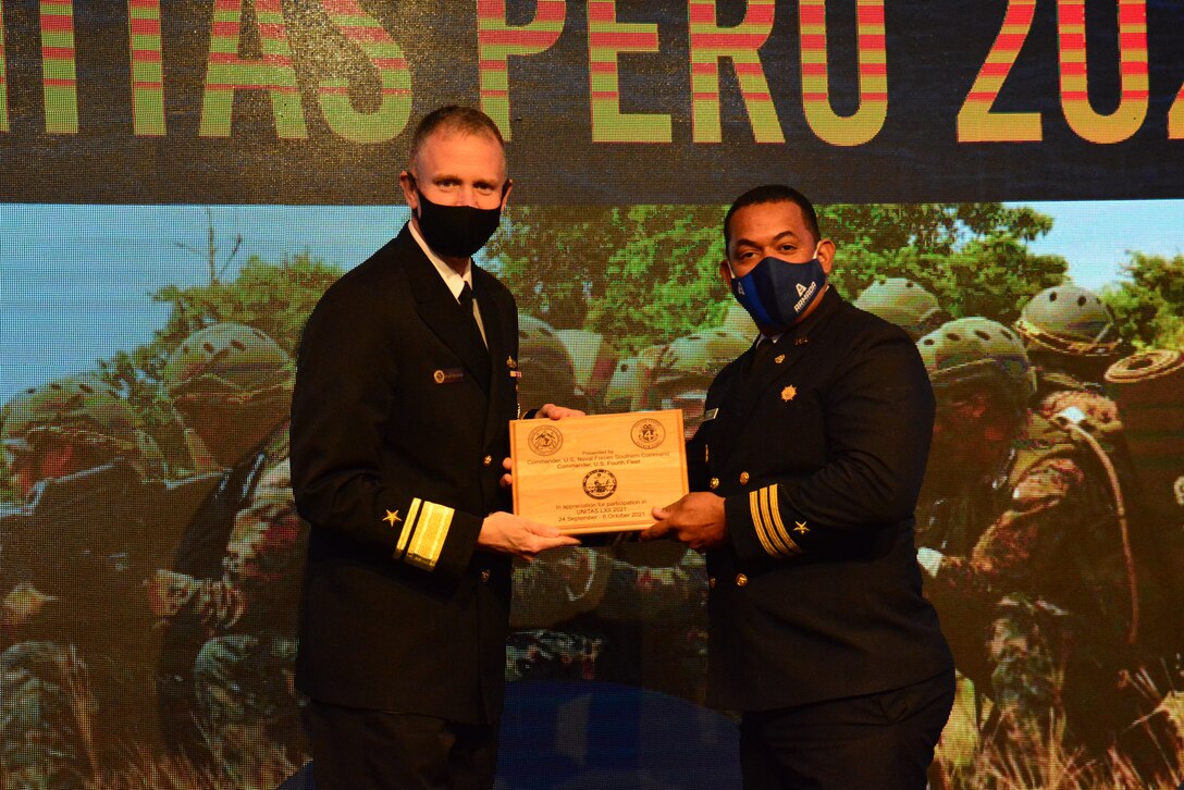 Rear Adm. Jim Aiken, commander of U.S. Naval Southern Forces Command/U.S. 4th Fleet, awards a plaque to Colombian Naval Cdr. German Castro Triana during the closing ceremony at Delfines Hotel and Convention Center during UNITAS LXII, Oct. 6, 2021.