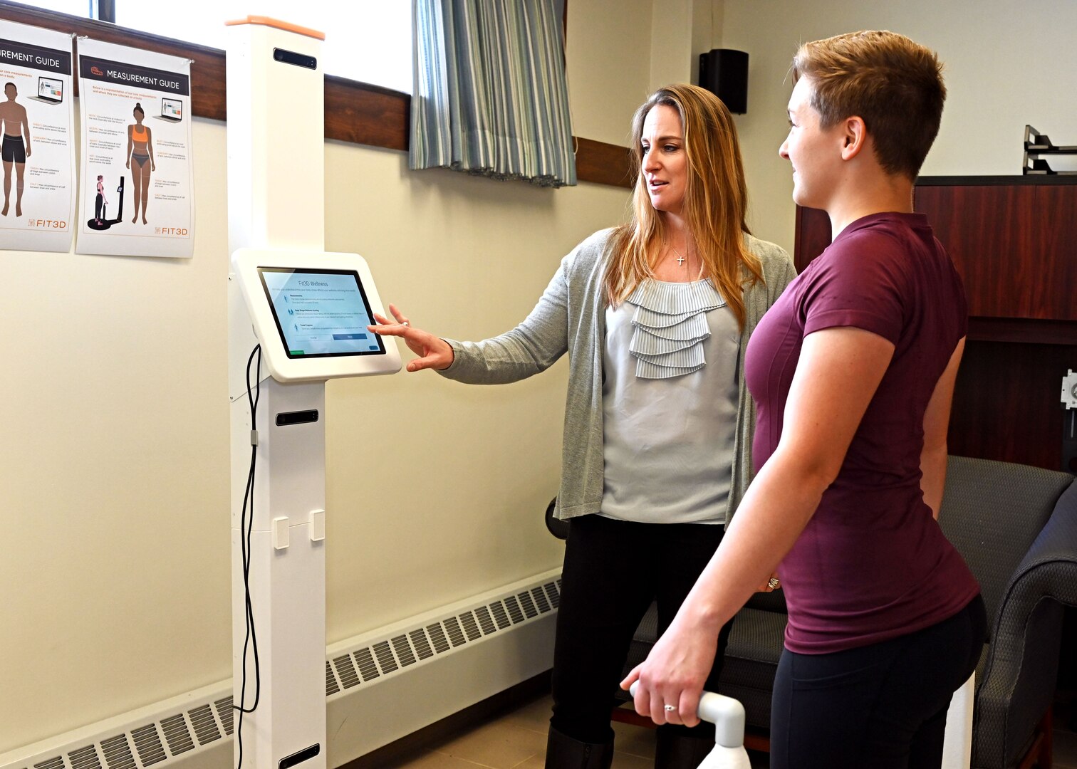 From left, Heather Taylor and Pfc. Kayla Abele of the NHARNG state wellness program demonstrate the high-tech FIT3D Full Body Scanner on Oct. 5, 2021, at the state military reservation in Concord.