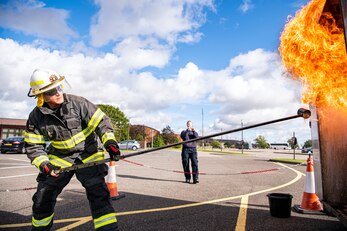 Dave Herman, 423rd Civil Engineer Squadron assistant chief of fire prevention, demonstrates a grease fire during a safety briefing at RAF Alconbury, England, Oct. 4, 2021. The demonstration was a part of Fire Prevention Week which allowed firefighters from the 423rd CES to educate Airmen and family members from the 501st Combat Support Wing on proper fire safety habits. (U.S. Air Force photo by Senior Airman Eugene Oliver)