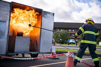 Dave Herman, 423rd Civil Engineer Squadron assistant chief of fire prevention, demonstrates a grease fire during a safety briefing at RAF Alconbury, England, Oct. 4, 2021.The demonstration was a part of Fire Prevention Week which allowed firefighters from the 423rd CES to educate Airmen and family members from the 501st Combat Support Wing on proper fire safety habits. (U.S. Air Force photo by Senior Airman Eugene Oliver)