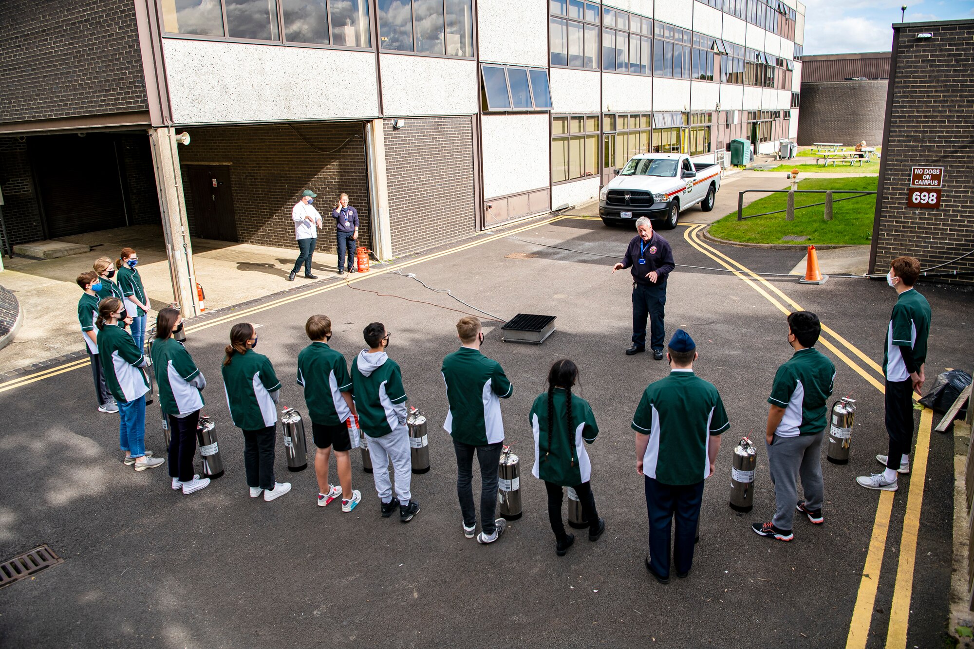 A firefighter from the 423rd Civil Engineer Squadron briefs students from Alconbury Middle Highschool prior to fire extinguisher training at RAF Alconbury, England, Oct. 4, 2021. The brief was a part of Fire Prevention Week which allowed firefighters from the 423rd CES to educate Airmen and family members from the 501st Combat Support Wing on proper fire safety habits. (U.S. Air Force photo by Senior Airman Eugene Oliver)
