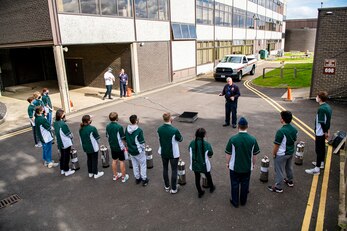 A firefighter from the 423rd Civil Engineer Squadron briefs students from Alconbury Middle Highschool prior to fire extinguisher training at RAF Alconbury, England, Oct. 4, 2021. The brief was a part of Fire Prevention Week which allowed firefighters from the 423rd CES to educate Airmen and family members from the 501st Combat Support Wing on proper fire safety habits. (U.S. Air Force photo by Senior Airman Eugene Oliver)