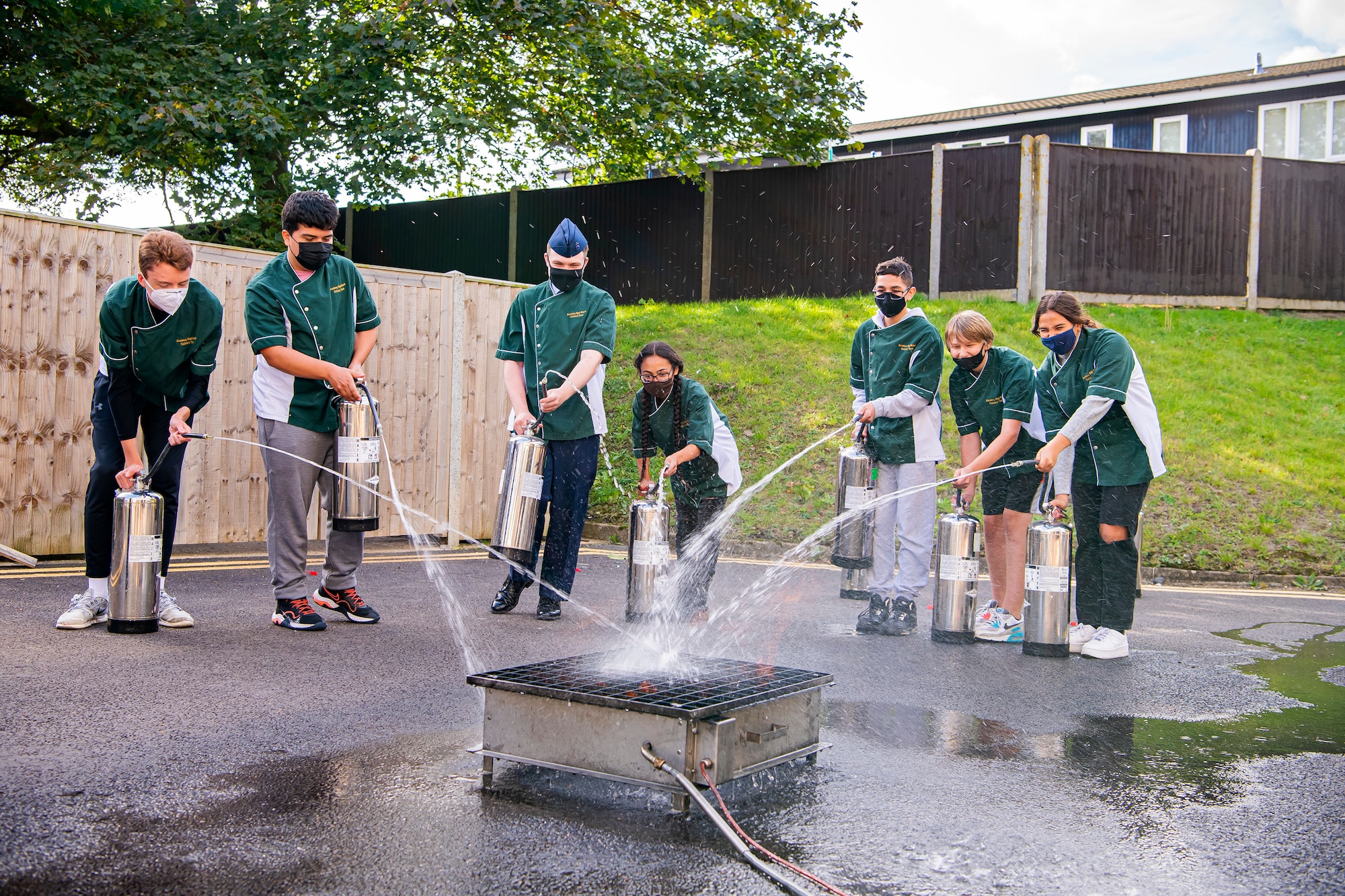 Students from Alconbury Middle Highschool extinguish a fire during safety training at RAF Alconbury, England, Oct. 4, 2021. The training was a part of Fire Prevention Week which allowed firefighters from the 423rd CES to educate Airmen and family members from the 501st Combat Support Wing on proper fire safety habits. (U.S. Air Force photo by Senior Airman Eugene Oliver)