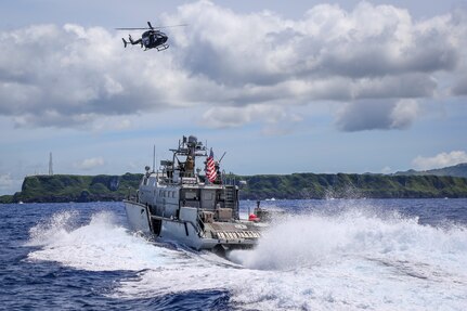 A Guam Army National Guard UH-72 Lakota helicopter from 1-224th Aviation Regiment Delta Company hovers over a U.S. Navy Mark VI from Maritime Expeditionary Security Squadron (MSRON) 4 Bravo Company, during a joint exercise off the coast of Guam, Sept. 28, 2021. The exercise, intended to familiarize the two units with casualty evacuation and interoperability, was the first of its kind for the Guam Army National Guard and MSRON 4.