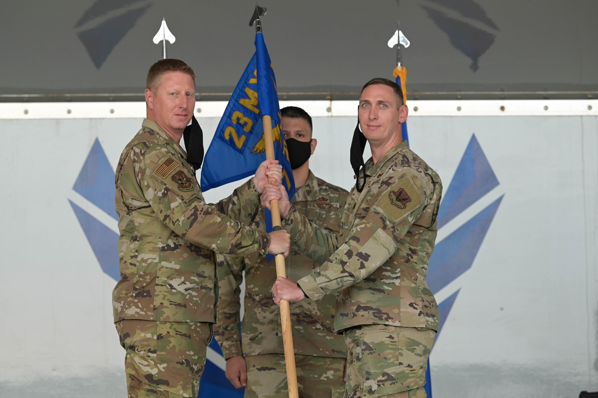 U.S. Air Force Col. Jason Purdy, 23rd Maintenance Group commander, left, passes the guide-on to U.S. Air Force Capt. Patrick Britton, 71st Rescue Generation Squadron commander, right, to assume command of the newly activated squadron at Moody Air Force Base, Georgia, Oct. 1, 2021. Combat search and rescue is a "can't-fail" mission, and it's imperative that the squadrons are ready to fly, fight and win. (U.S. Air Force photo by Senior Airman Rebeckah Medeiros)