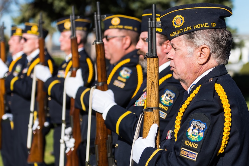Veterans hold rifles while in formation.