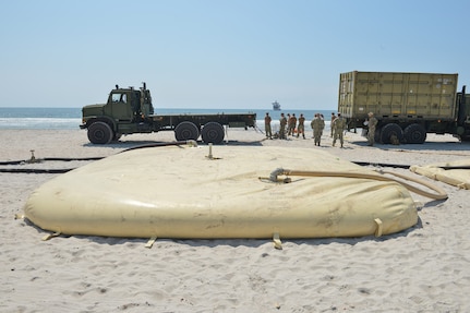 A 20,000 gallon collapsible fabric tank is filled with salt water as a test of the distributed littoral operational fuel transfer system (DLOFTS) by Navy Cargo Handling Battalion ONE on Onslow beach, N.C. as part of Large-Scale Exercise (LSE 21), Aug 7, 2021.