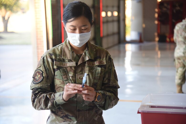 U.S. Air Force Senior Airman Angelina Lee, 17th Healthcare Operations Squadron aerospace allergy and immunization tech, prepares a flu vaccine.