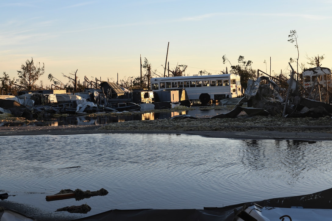 Piles of rubble surround a motor pool.