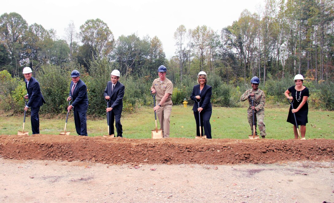 7 people pose with shovels for a groundbreaking