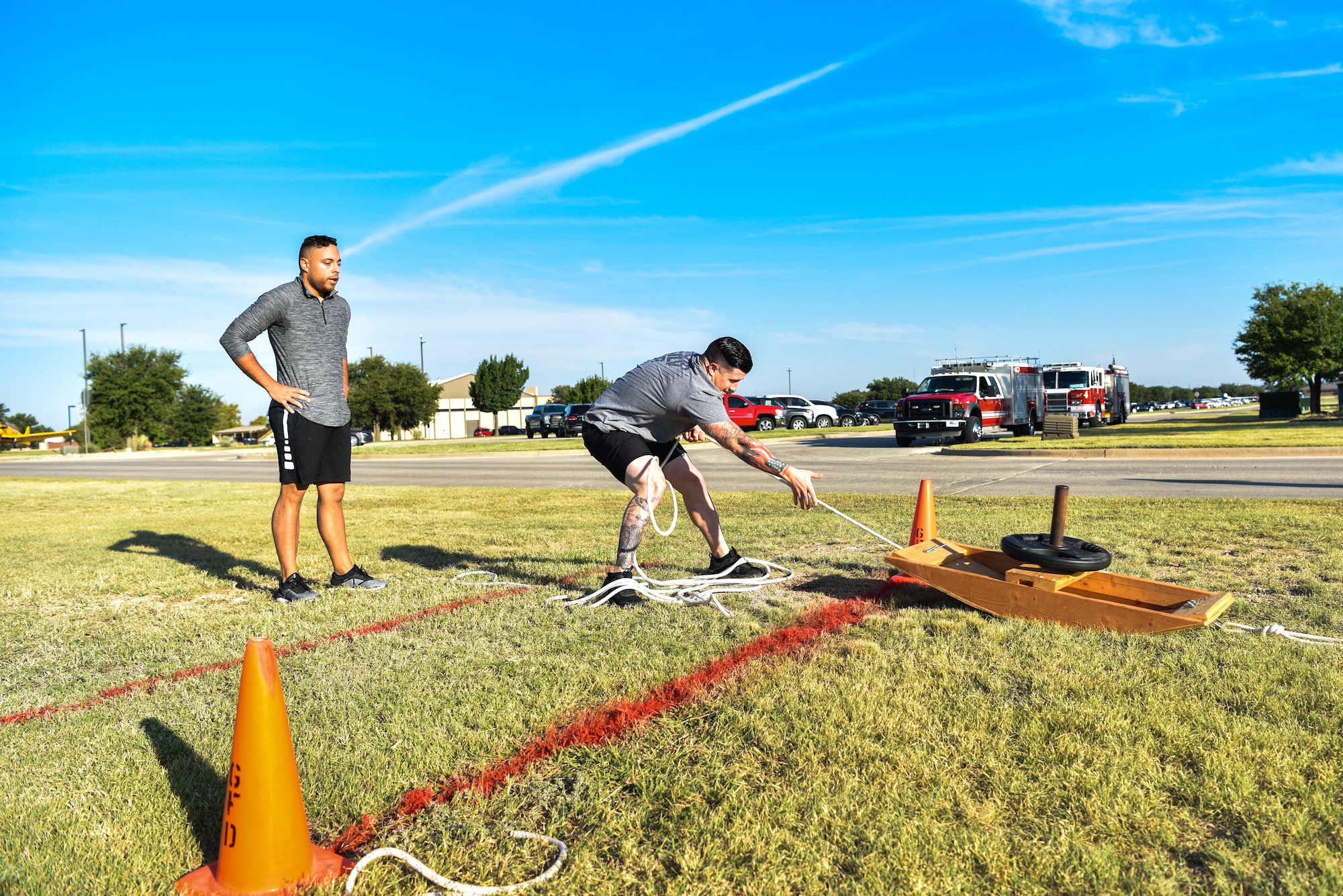 A member from the 17th Civil Engineer Squadron pulls a weighted sled during the Annual Fire Muster Challenge on Goodfellow Air Force Base, Texas, Oct. 8, 2021. Team members worked together to pull a weighted sled 50-feet before moving to the next obstacle course during the challenge. (U.S. Air Force photo by Senior Airman Jermaine Ayers)