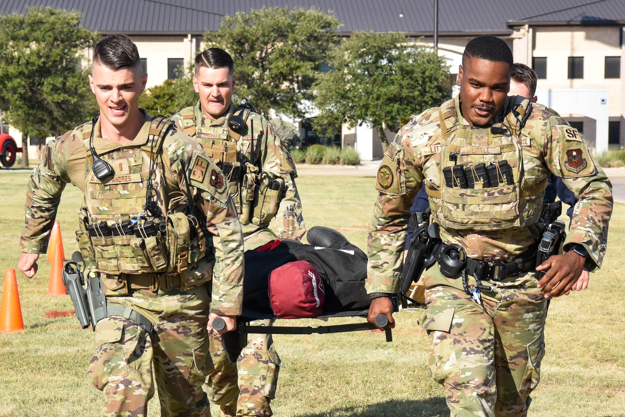 Members from the 17th Security Forces Squadron carry a training dummy during the Annual Fire Muster Challenge on Goodfellow Air Force Base, Texas, Oct. 8, 2021. During the challenge, teams carried a 110-pound dummy 50 feet and back as one of six activities in the competition. (U.S. Air Force photo by Senior Airman Jermaine Ayers)