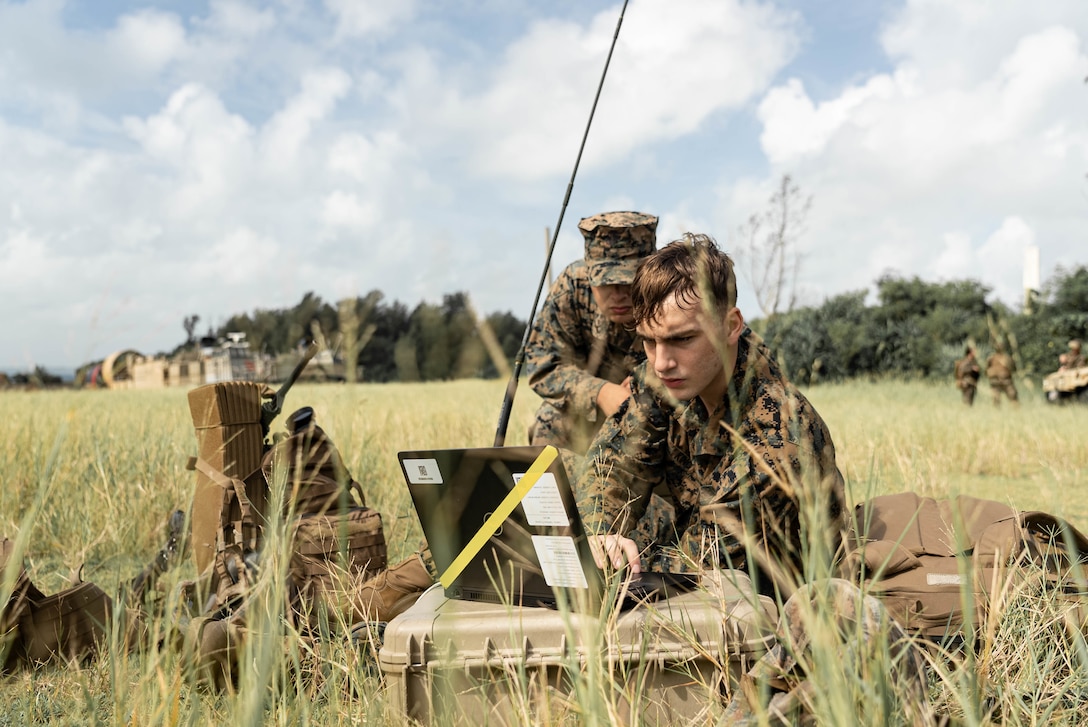 U.S. Marine Corps Cpl. Benjamin King, right, and Lance Cpl. Juan Rivera Mejia, left, both field radio operators with Combat Logistics Regiment 3, 3rd Marine Logistics Group establish communications during an amphibious landing exercise at Kin Blue, Okinawa, Japan, Oct. 6. CLR-3 Marines and Sailors familiarized themselves with amphibious ship to shore landing procedures from an LCAC in preparation for future operations. 3d MLG, based out of Okinawa, Japan, is a forward-deployed combat unit that serves as III Marine Expeditionary Force’s comprehensive logistics and combat service support backbone for operations throughout the Indo-Pacific area of responsibility.