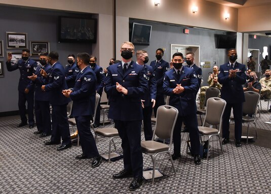 Graduates of Airman Leadership School Class 21-G stand as they are recognized