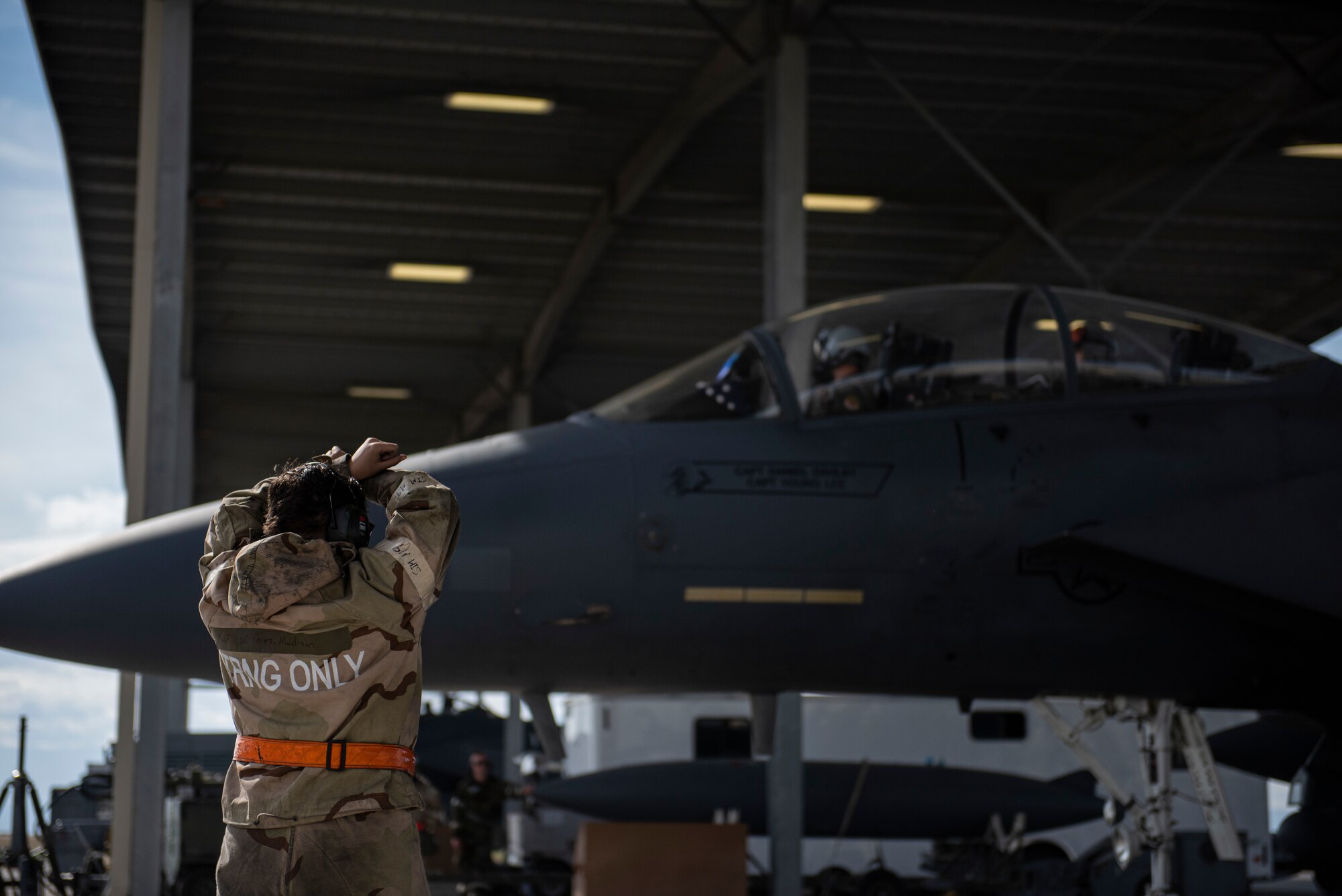 An Airman Taxis a F-!%E Strike Eagle into a hangar