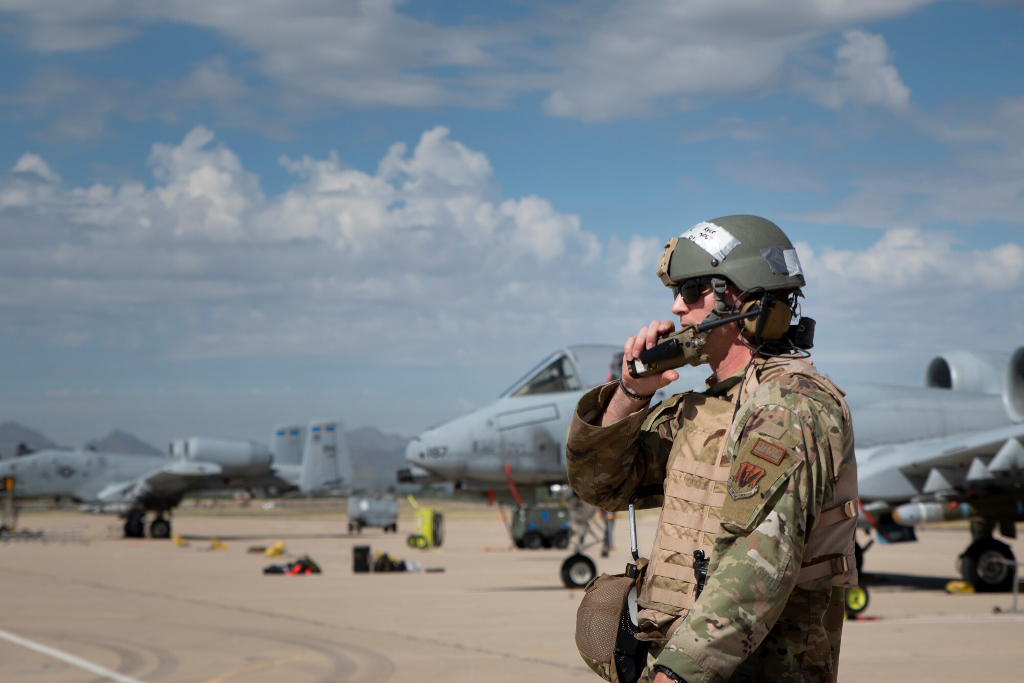 Man speaks into radio on the flight line.