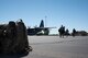 People unload from an aircraft on the flight line.