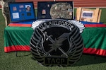 Table draped in green cloth with military items honoring fallen airman