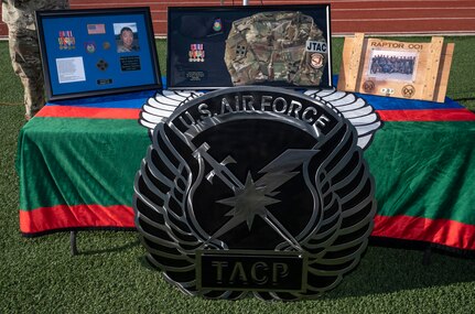 Table draped in green cloth with military items honoring fallen airman