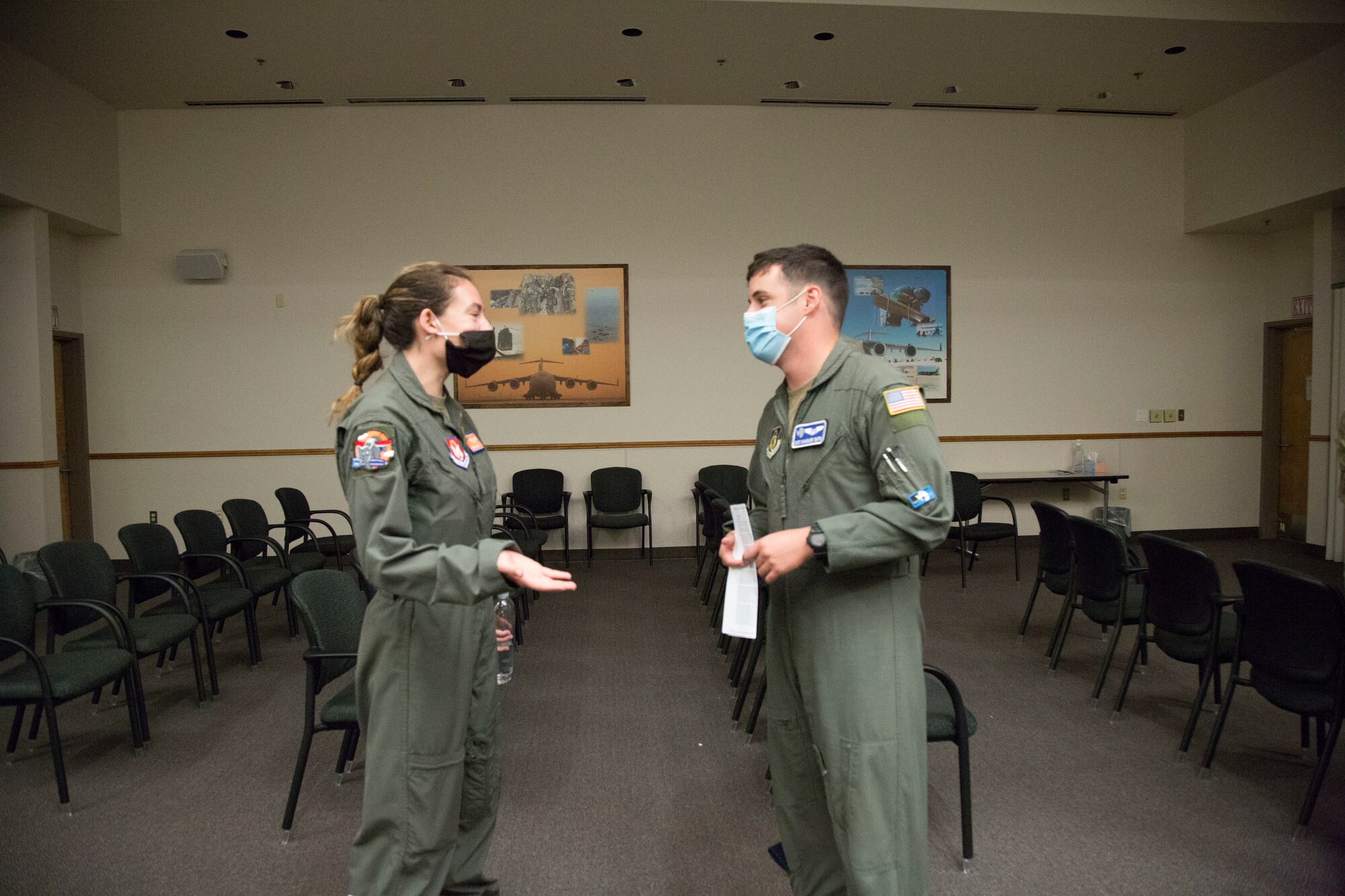 Two airmen talking to each other in an auditorium