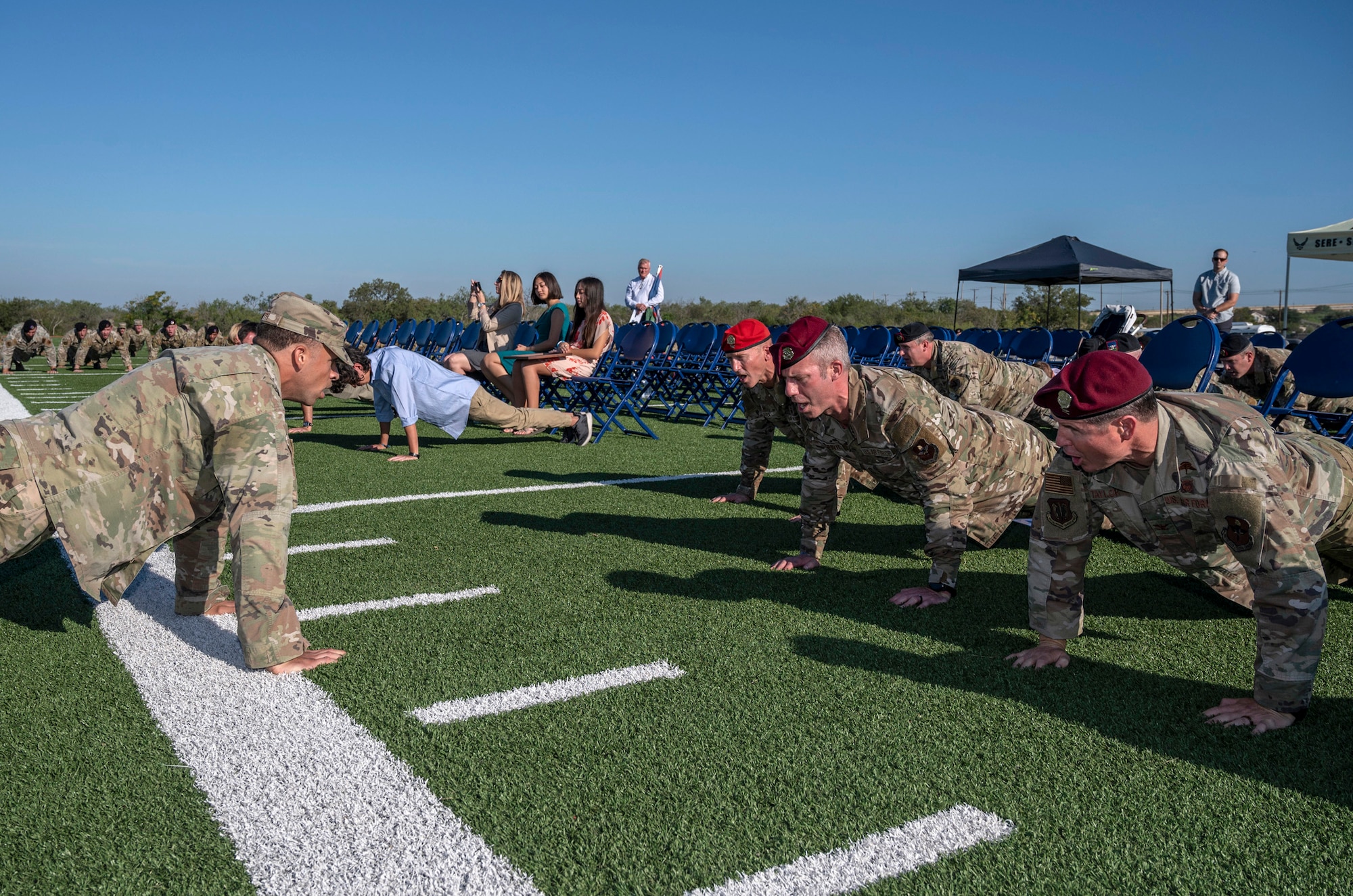 Dozens of military members performing pushups