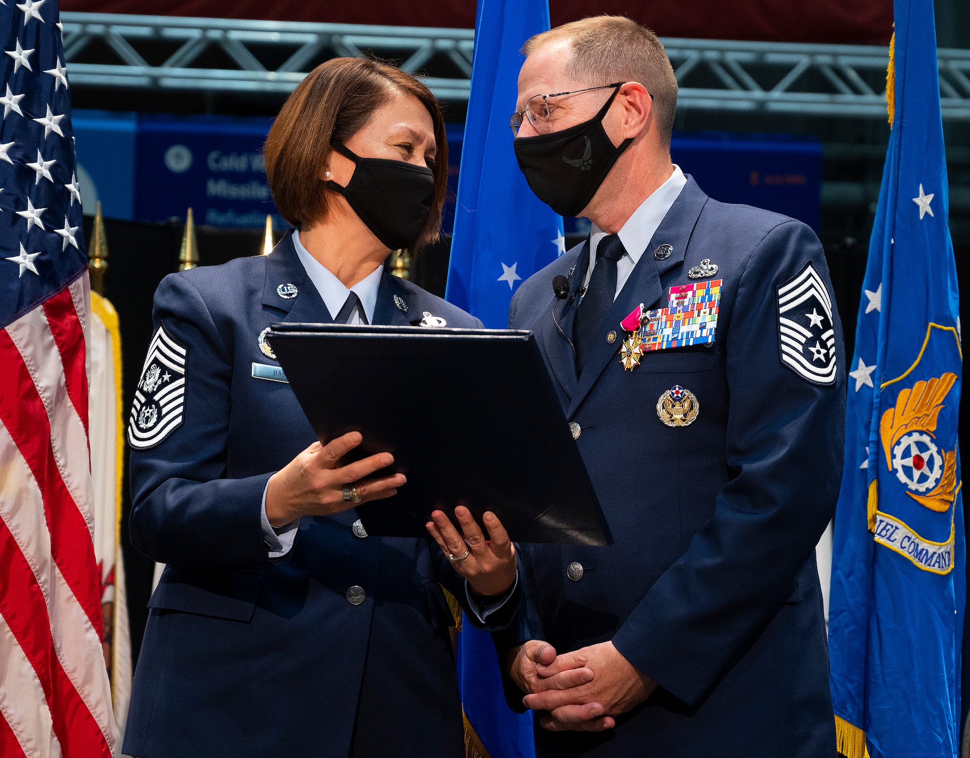 Chief Master Sgt. of the Air Force JoAnne S. Bass presents Chief Master Sgt. Stanley C. Cadell, Air Force Materiel Command command chief, with a certificate of appreciation Oct. 1, 2021, in the National Museum of the Air Force at Wright-Patterson Air Force Base, Ohio. Cadell retired after completing 30 years of service. (U.S. Air Force photo by R.J. Oriez)