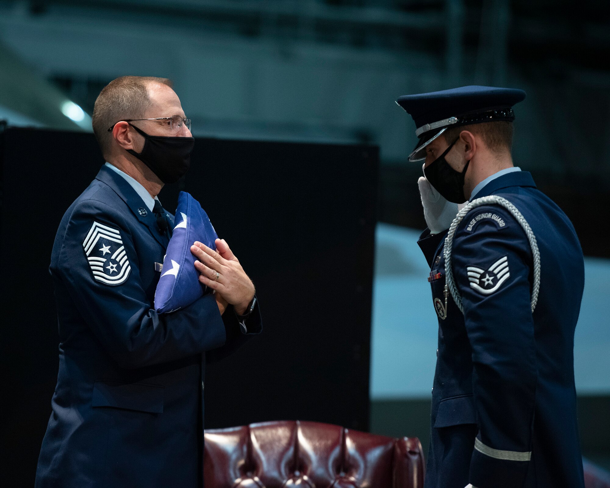 Chief Master Sgt. Stanley Cadell (left), Air Force Materiel Command command chief, is saluted by a Wright-Patterson Air Force Base Honor Guard member during his retirement ceremony Oct. 1, 2021, in the National Museum of the U.S. Air Force at Wright-Patterson Air Force Base, Ohio. Cadell retired after 30 years of service. (U.S. Air Force photo by R.J. Oriez)