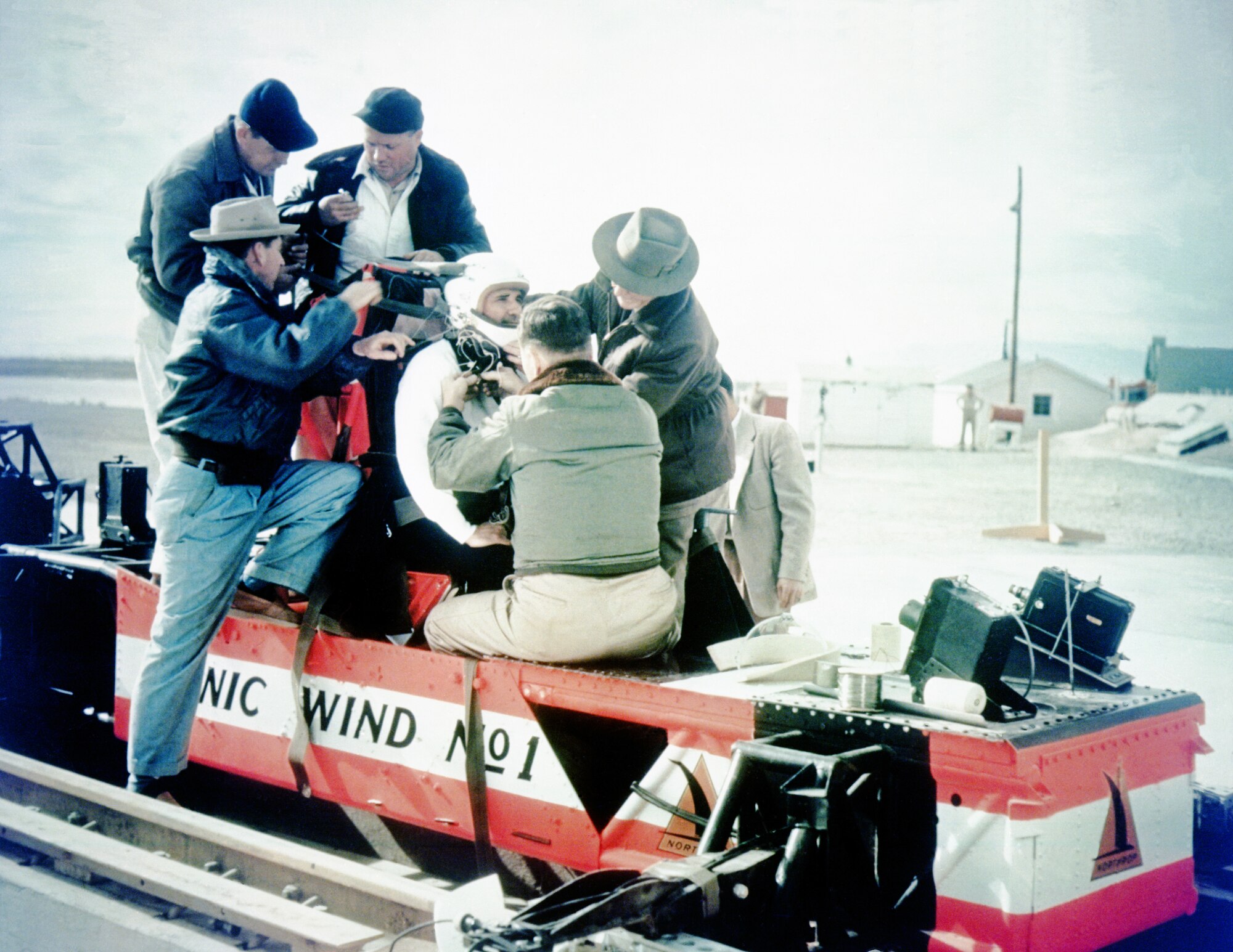 A Holloman High Speed Test Track crew secures Lt. Col. John Stapp into the “Sonic Wind No. 1” rocket sled at Holloman Air Force Base, New Mexico. It was at the HHSTT that Stapp earned the title of “Fastest Man on Earth.” During a launch on Dec. 10, 1954, a sled ridden by Stapp traveled at a speed of 632 miles per hour. Stapp endured around 40 times the pull of the earth’s gravity. This ride broke the land speed record. This was among several records set at the HHSTT, and the test track’s history is one of the reasons the 846th Test Squadron, which operates the more-than-70-year-old facility, is exploring its modernization. The 846 TS is a unit of the 704th Test Group of the Arnold Engineering Development Complex, headquartered at Arnold Air Force Base, Tenn. (U.S. Air Force photo)